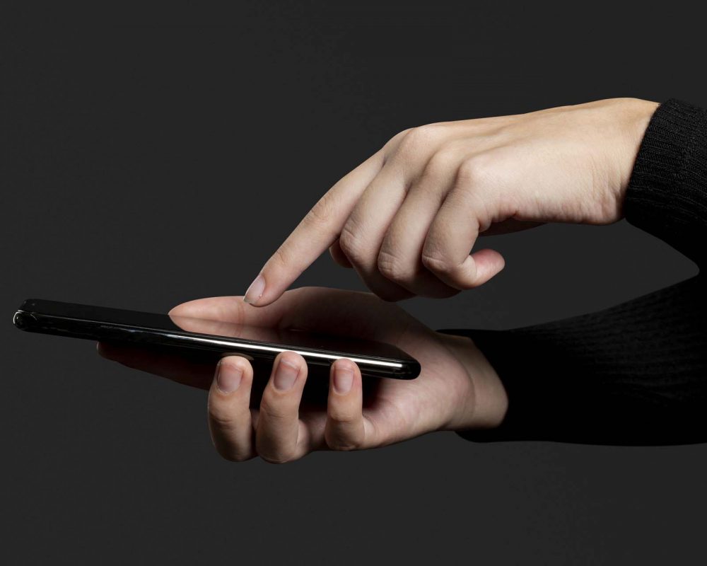 Finger pressing on a smartphone screen