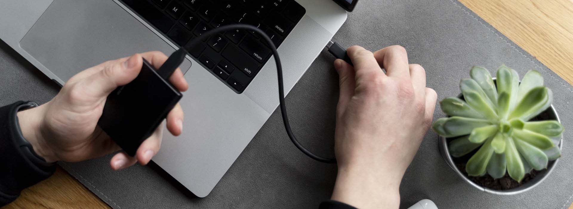 hands-plugging-ssd-device-top-view